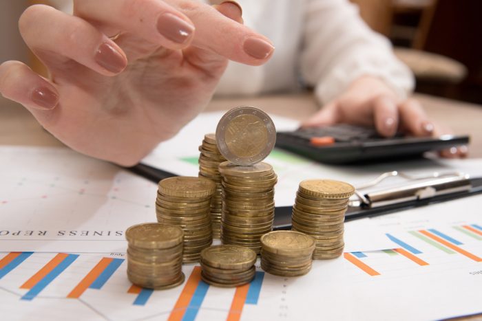 woman building coin-stacks above graphs